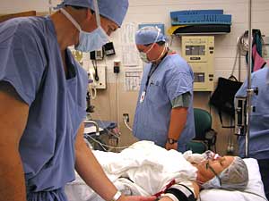
Orthopedic surgeon Mark Holm checks how his patient, Theresa Albright-Fischer, is doing just before surgery. (MPR Photo/Lorna Benson)