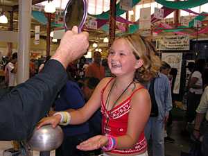 
Kayla Jones learns about static electricity at the Bakken Museum booth at the Minnesota State Fair.  (MPR Photo/Lorna Benson)
