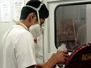 
Luis Gomez, 20, mixes paint in the shop at the Newgate School.  He eventually wants to open his own auto body shop.   (MPR Photo/Toni Randolph)