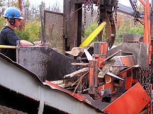 
An hydraulic log splitter cuts wood to length, and slices the round round logs into smaller pieces for burning.  The machine can be set for a customer's specific wood size needs.   (MPR Photo/Bob Kelleher)