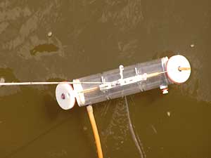
Volunteer Tim Olson dropped this plastic tube into the Red River to collect a water sample. He then checks the sample for levels of various pollutants. (MPR Photo/Dan Gunderson)
