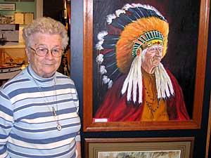 
Former Warroad Mayor Ruth Stukel is president of the Warroad Historical Society. She says the local Warroad Indian group deserves to get formal recognition as a tribe from the federal government. Stukel is pictured with a portrait of Kakaygeesick, or Everlasting Sky.  (MPR photo/Tom Robertson)