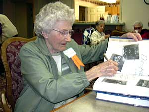 
Hazel Peterson Blanchard signs books for admirers.  She played for the team in the mid-'30s. (MPR Photo/Jayne Solinger)