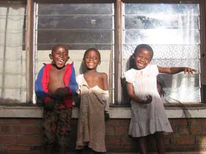 
The Nyirongo grandchildren Smarty, Siphiwe, and Adinafe enjoy a sunny afternoon on the back porch. (Photo: Jonah Eller-Isaacs)